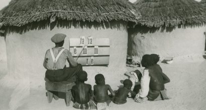 vanha valokuva, jossa afrikkalainen mies opettaa pojille tavaamista