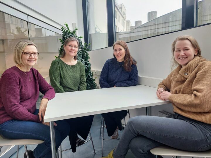 Kuvassa artikkelin kirjoittajat istuvat pöydän ääressä.