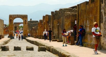 Turisteja Pompeijin Via Mercurion raunioilla aurinkoisena kesäpäivänä.