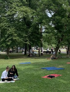 Ihmisiä lukemassa nurmikolla Kupittaanpuistossa