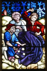 Yksityiskohta Sainte-Walburgen kirkon lasimaalauksesta: la tunique tirée au sort (Wikimedia Commons).