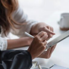 Kädet osoittaa tablettia.