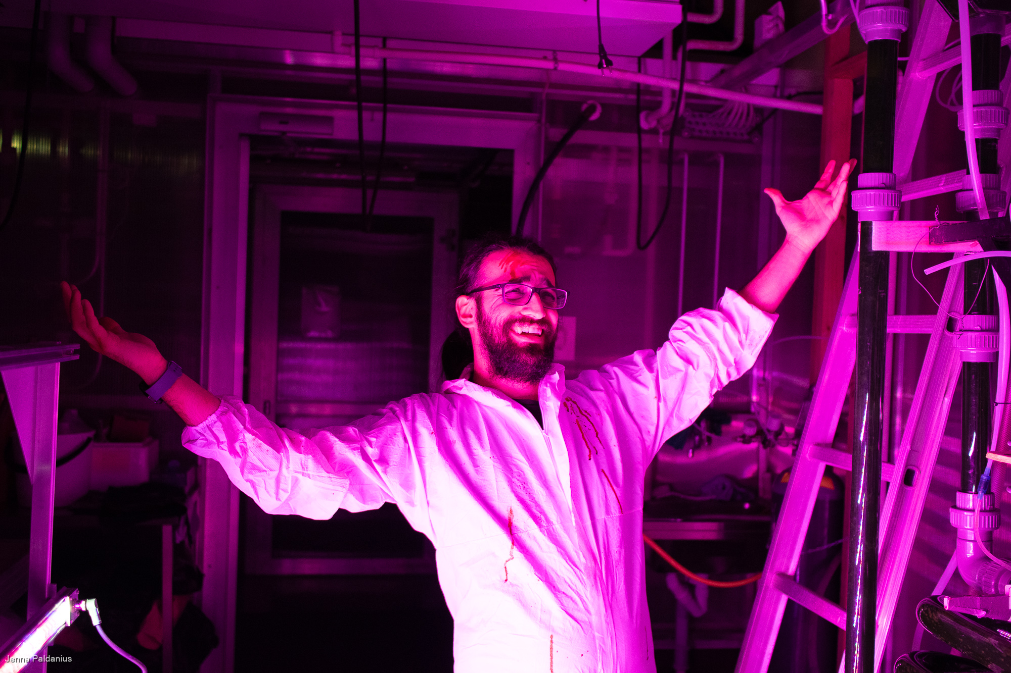 Emren Borhan laboratoriossa magentan värisessä valaistuksessa.