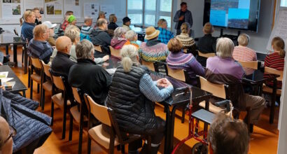 Luentosali täynnä yleisöä kuuntelemassa esitystä