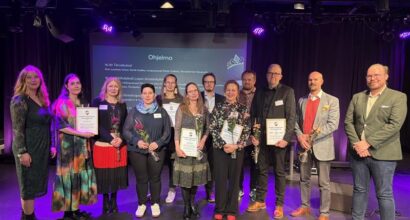 ryhmä ihmisiä poseeraa diplomit kädessään