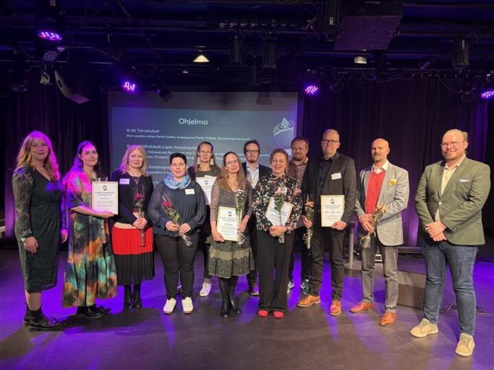 ryhmä ihmisiä poseeraa diplomit kädessään