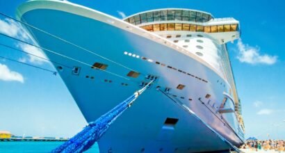 Valkoinen risteilylaiva kuvattuna laiturilta keulasta päin