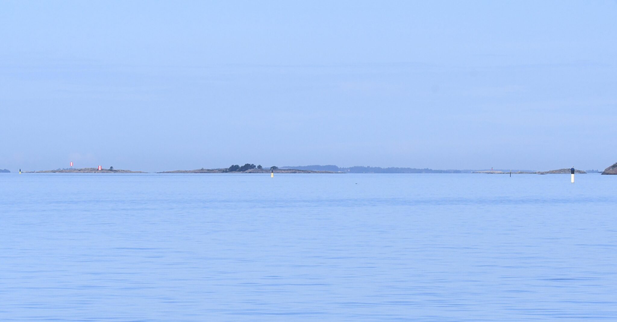 Utuinen aava meri horisontissa saaria ja merimerkkejä