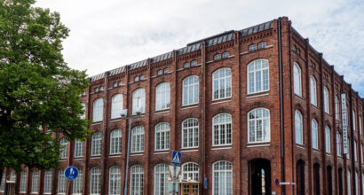 Vanha punatiilinen tehdasrakennus ja valkoiset ikkunanapuitteet
