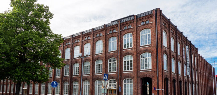 Vanha punatiilinen tehdasrakennus ja valkoiset ikkunanapuitteet