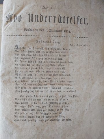 Sanomalehden Åbo Underrättelser etusivu vuodelta 1824. Kirjoitettu fraktuuralla.