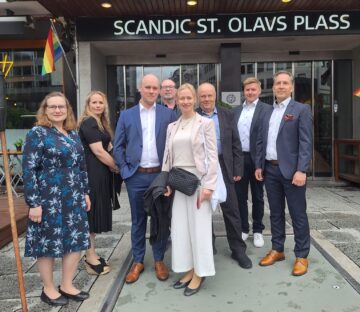 Naisia ja miehiä asettunut seisomaan Scandic St. Olavs Plass -hotellin pääoven eteen ryhmäkuvaan