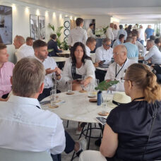 Ihmisiä istuu pöydän ympärillä keskustelemassa