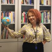 Photo of Mila Seppälä smiling while holding a globe against a backdrop of a bookshelf. Links to her profile at the University of Turku website.