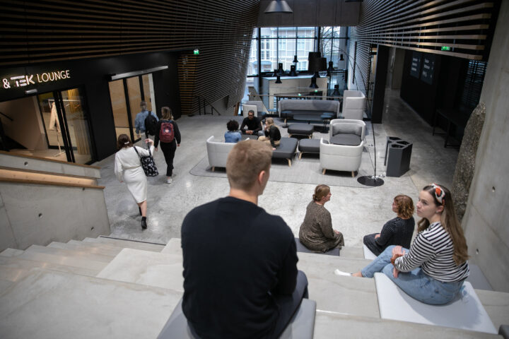 People sitting on steps inside a university building