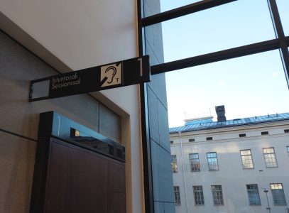 Näkymä Varsinais-Suomen käräjäoikeudesta, jossa salin oven yläpuolella kuulosilmukka-merkki.
