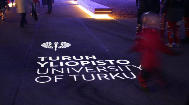 Turun yliopiston logo heijastettuna maahan 100-vuotisjuhlassa yliopistonmäellä.
