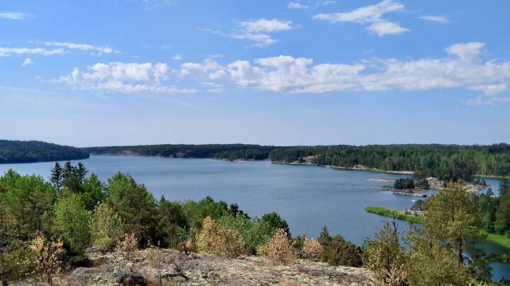 Kesäinen maisema Turun saaristossa: vettä, kallioisia ja metsäisiä saaria, sinisellä taivaalla valkoisia pilviä