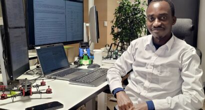 Amos Alwala sitting at a desk by a computer
